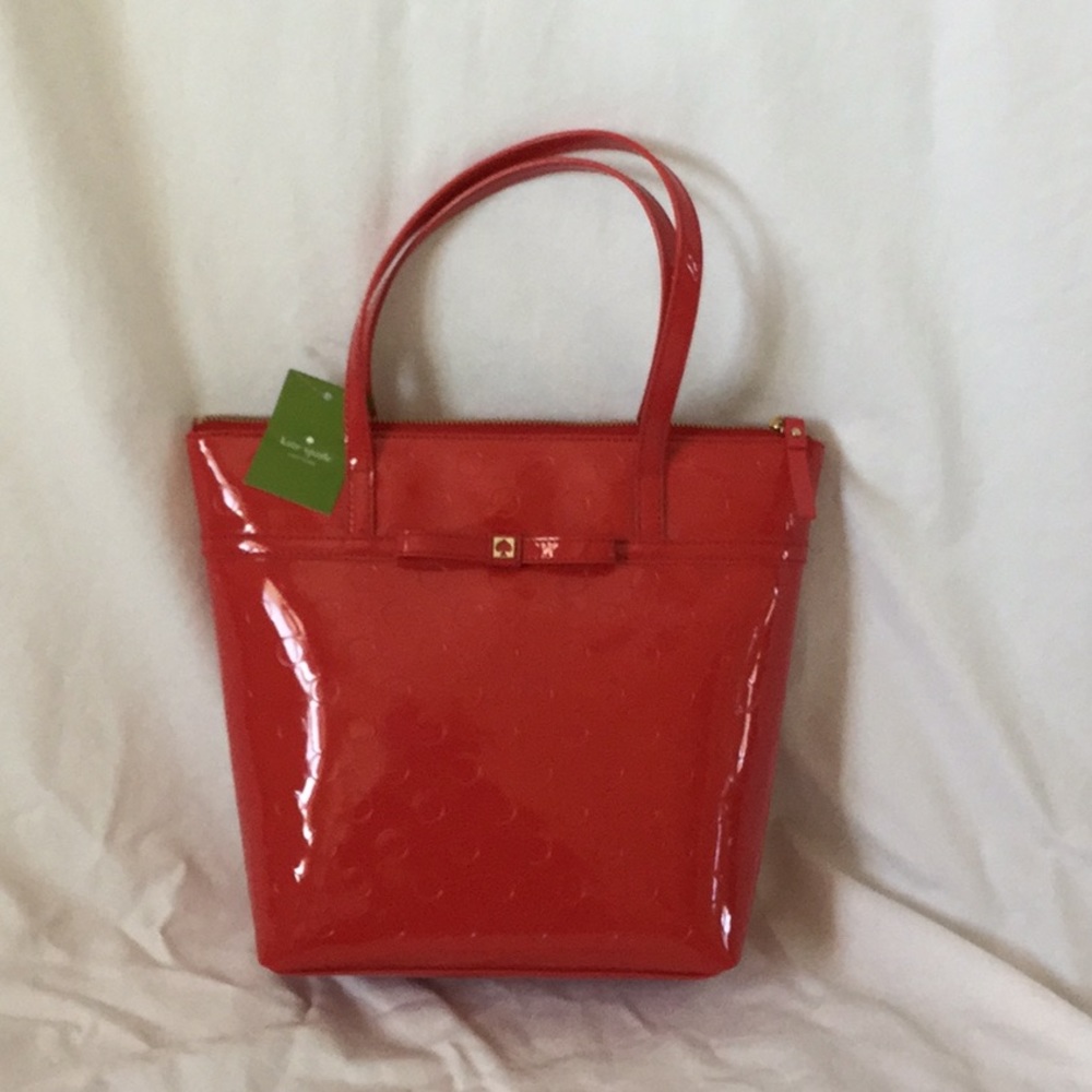 Red patent leather purse with polka dot imprint.